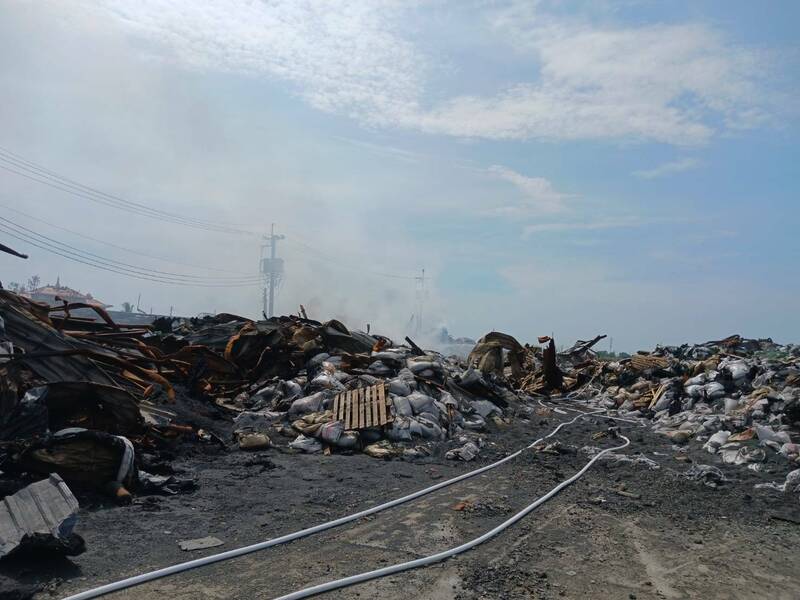 高市永安区保安路一间地下塑胶工厂前天发生火警，业者今天以重机具整理现场，结果发生复燃。（民众提供）（记者苏福男摄）